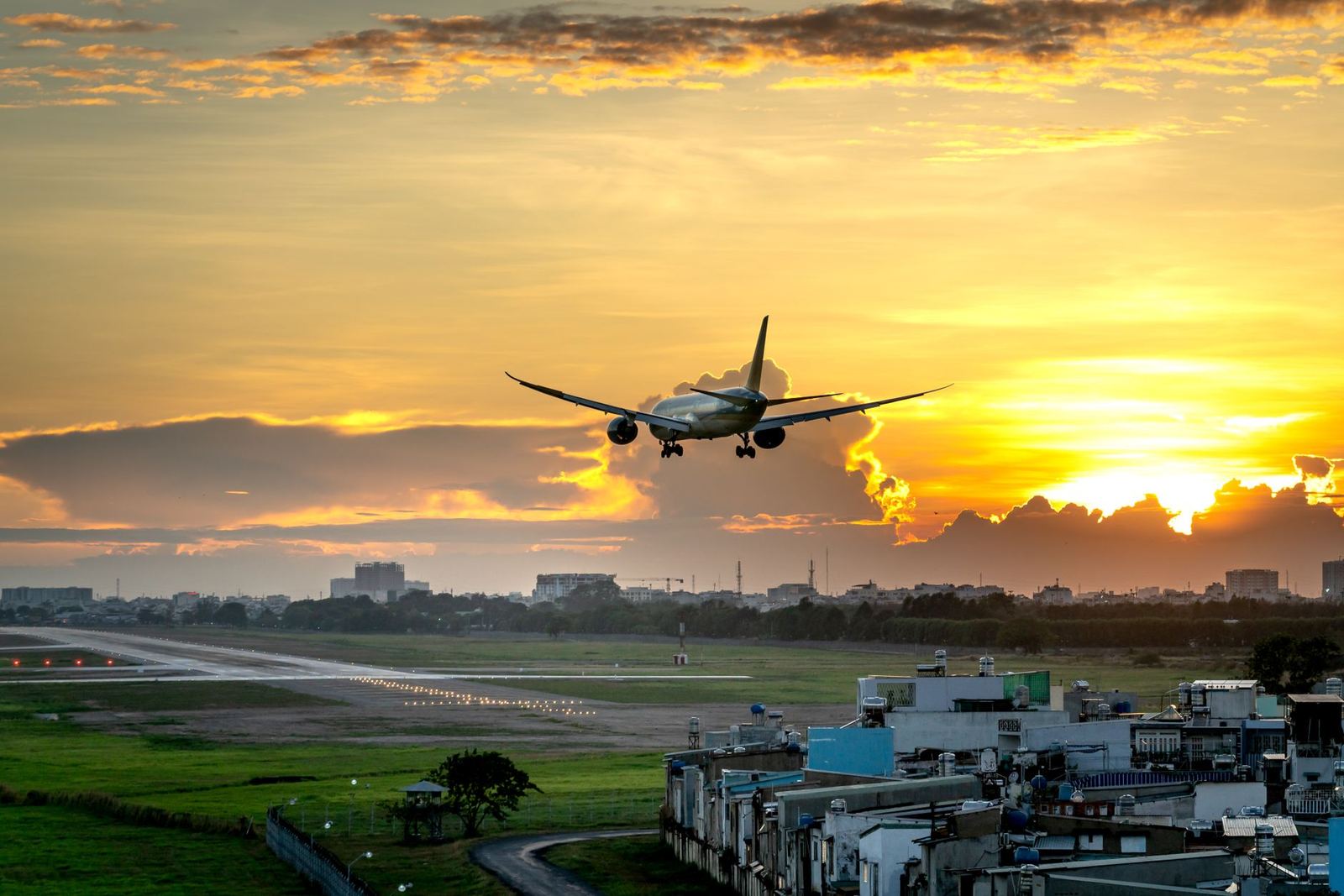 Airliner climbing away from a runway at sunset